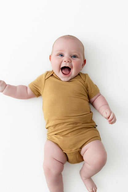 Kyte Baby Bodysuit in Ochre